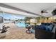Covered patio features comfortable seating, a ceiling fan, and scenic view of the waterfront and pool at 8848 Sunlit Cove Ne Dr, St Petersburg, FL 33702