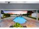 A relaxing outdoor view featuring a pool, water view and comfortable seating at 8848 Sunlit Cove Ne Dr, St Petersburg, FL 33702