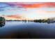 Waterfront view with a calm surface reflecting the colorful sunset enhances the natural beauty of the location at 8848 Sunlit Cove Ne Dr, St Petersburg, FL 33702
