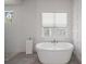 Bright main bathroom featuring a soaking tub, tiled floor, and a glass-enclosed shower at 911 S Sterling Ave, Tampa, FL 33629