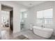 Elegant main bathroom featuring a soaking tub, tiled floor, and a glass-enclosed shower at 911 S Sterling Ave, Tampa, FL 33629
