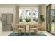 Airy dining room with large windows, a wooden table with seating for four, and modern decor at 9406 Gladsome Dr, Land O Lakes, FL 34637
