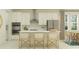 Modern kitchen featuring white cabinets, stainless steel appliances, and a center island with bar seating at 9406 Gladsome Dr, Land O Lakes, FL 34637