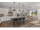 Open concept kitchen featuring a center island with seating, stainless steel appliances, and an adjacent dining area at 9962 Trellis Vine Way, Parrish, FL 34219