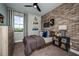 Modern bedroom boasts a brick accent wall, skateboard decor, and sleek black ceiling fan at 9997 Surrey Rose Dr, San Antonio, FL 33576