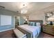 Comfortable bedroom featuring a crystal chandelier, brick accent wall, and neutral color palette at 9997 Surrey Rose Dr, San Antonio, FL 33576