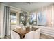Bright dining room with natural light, modern chandelier, and view of the manicured lawn at 9997 Surrey Rose Dr, San Antonio, FL 33576
