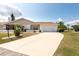 Well-manicured front yard leading to a cozy home with an attached two-car garage at 106 Silverbell Ct, Sun City Center, FL 33573