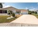 Well-manicured front yard leading to a cozy home with an attached two-car garage at 106 Silverbell Ct, Sun City Center, FL 33573