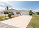 Well-manicured front yard leading to a cozy home with an attached two-car garage at 106 Silverbell Ct, Sun City Center, FL 33573