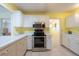 Bright eat-in kitchen featuring stainless steel appliances, white cabinetry, and tile flooring at 106 Silverbell Ct, Sun City Center, FL 33573