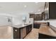 Well-lit kitchen with a central island, stainless steel appliances, and a view of the adjacent living area at 1119 Ballard Green Pl, Brandon, FL 33511