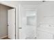 Bright laundry room with white washer and dryer, open doors leading to the bedroom and closet space at 1119 Ballard Green Pl, Brandon, FL 33511