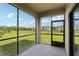 Screened lanai showcasing views of manicured lawn and nearby residential building under a blue sky at 1119 Ballard Green Pl, Brandon, FL 33511