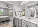 Bright bathroom with double vanity, large mirror, and a doorway leading to the Primary bedroom at 11322 Lake Lucaya Dr, Riverview, FL 33579
