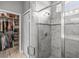 Bathroom with a glass-enclosed shower stall and a walk-in closet filled with clothes and shoes at 11322 Lake Lucaya Dr, Riverview, FL 33579