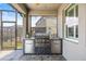 Covered outdoor kitchen area featuring a built-in grill and a sink for convenient outdoor cooking at 11322 Lake Lucaya Dr, Riverview, FL 33579