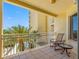 Inviting balcony with comfortable seating and a view of palm trees and the bay at 1200 Gulf Blvd # 404, Clearwater Beach, FL 33767