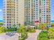 Stunning building exterior featuring lush landscaping and convenient covered entry with a circular drive at 1200 Gulf Blvd # 404, Clearwater Beach, FL 33767