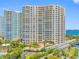 Exterior shot of the large condominium complex with lush tropical landscaping at 1200 Gulf Blvd # 404, Clearwater Beach, FL 33767