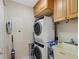 Functional laundry area with stacked washer and dryer, storage, and utility sink at 1200 Gulf Blvd # 404, Clearwater Beach, FL 33767