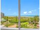 Beautiful beach and ocean view through a large glass window with palm trees in the foreground at 1200 Gulf Blvd # 404, Clearwater Beach, FL 33767