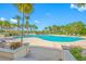 Resort-style community pool surrounded by lush landscaping and palm trees with plenty of lounge seating at 1200 Gulf Blvd # 404, Clearwater Beach, FL 33767