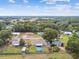 Aerial view of a quiet neighborhood with mature trees, homes, and one with an above-ground backyard pool at 12106 Meadow Ln, San Antonio, FL 33576