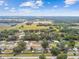 A wide aerial view of a peaceful neighborhood, showcasing mature trees, homes and a glimpse of a backyard pool at 12106 Meadow Ln, San Antonio, FL 33576