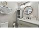 Stylish bathroom featuring gray vanity, round mirror, and modern lighting at 12106 Meadow Ln, San Antonio, FL 33576