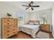 Bedroom showcasing natural lighting, hardwood floors, bed, and dresser at 12106 Meadow Ln, San Antonio, FL 33576