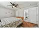 Bedroom with ensuite bathroom, geometric bedding, wood floors, and ceiling fan at 12106 Meadow Ln, San Antonio, FL 33576