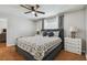 Bedroom featuring wood floors, ceiling fan, geometric bedding, and white nightstand at 12106 Meadow Ln, San Antonio, FL 33576