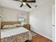 Cozy bedroom with a floral-themed bed, natural light, and modern ceiling fan at 12106 Meadow Ln, San Antonio, FL 33576