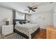 Bright bedroom with wood floors, stylish patterned bedding, ceiling fan, and dresser at 12106 Meadow Ln, San Antonio, FL 33576