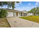 Lovely home showcasing a spacious driveway, attached garage, and manicured landscaping at 12106 Meadow Ln, San Antonio, FL 33576
