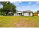 Charming single-story home with a well-manicured lawn, mature trees, and an attached garage at 12106 Meadow Ln, San Antonio, FL 33576