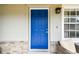 Close-up of the front door with stylish stone accents and a modern exterior light fixture at 12106 Meadow Ln, San Antonio, FL 33576