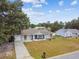 An inviting single-story home with a well-manicured lawn and a long driveway leading to an attached garage at 12106 Meadow Ln, San Antonio, FL 33576