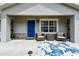 Inviting front porch with seating, a stylish rug, and a vibrant blue front door at 12106 Meadow Ln, San Antonio, FL 33576
