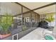 Relaxing enclosed porch with comfortable seating and a barbecue grill at 12106 Meadow Ln, San Antonio, FL 33576