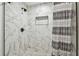 Modern shower with white marble-look tile and black hardware at 12106 Meadow Ln, San Antonio, FL 33576