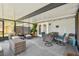Enclosed sunroom with cozy seating, dining table, and sliding doors to the backyard at 12106 Meadow Ln, San Antonio, FL 33576