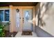 Close-up of front door with 'Welcome' mat and a decorative wreath sign creating a warm entrance at 12343 Ascot Ln, Spring Hill, FL 34609