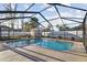Screened-in pool with newer concrete and landscaping at 12343 Ascot Ln, Spring Hill, FL 34609