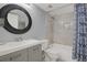 Well-lit bathroom with a tub-shower combination and a stylish round mirror above the sink at 12760 Indian Rocks Rd # 578, Largo, FL 33774