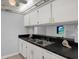 Kitchen sink with black countertops and white cabinets, accented by nautical decor at 12760 Indian Rocks Rd # 578, Largo, FL 33774