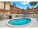Community hot tub with poolside lounge chairs, palm trees and white picket fence at 12760 Indian Rocks Rd # 578, Largo, FL 33774