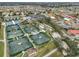 Aerial view showcases tennis courts, parking, and homes in a well-maintained community at 1304 Burbank Ct, Sun City Center, FL 33573