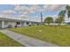 Beautifully landscaped exterior showcasing a well-manicured lawn and sidewalk in a tranquil neighborhood at 1304 Burbank Ct, Sun City Center, FL 33573